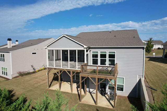 back of property with a yard and a patio area