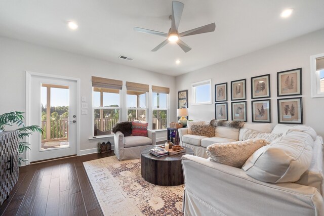 living room featuring ceiling fan, a wealth of natural light, and dark hardwood / wood-style flooring