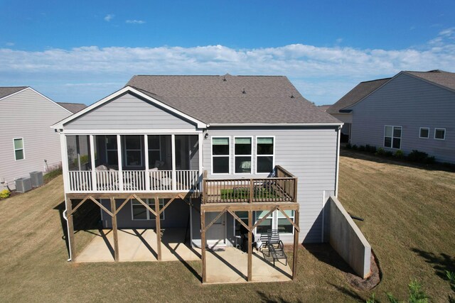 rear view of property featuring central AC unit, a yard, a sunroom, and a patio