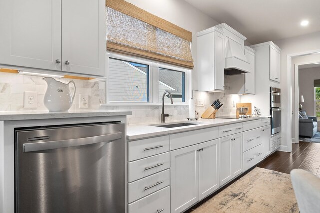 kitchen featuring tasteful backsplash, white cabinetry, sink, light stone counters, and stainless steel appliances