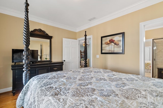 bedroom featuring crown molding, connected bathroom, and hardwood / wood-style flooring