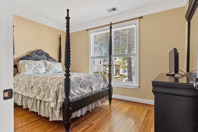 bedroom featuring crown molding and wood-type flooring