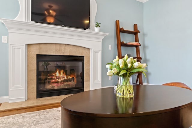 interior details with a tile fireplace and hardwood / wood-style floors