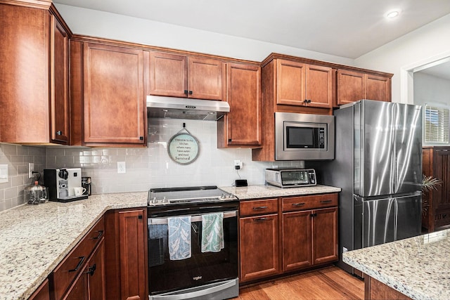 1000 Eight Knot Ct, Greensboro, GA 30642 - kitchen featuring stainless steel appliances, under cabinet range hood, tasteful backsplash, light wood finished floors, and light stone counters