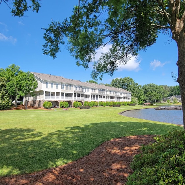 view of home's community featuring a water view and a yard