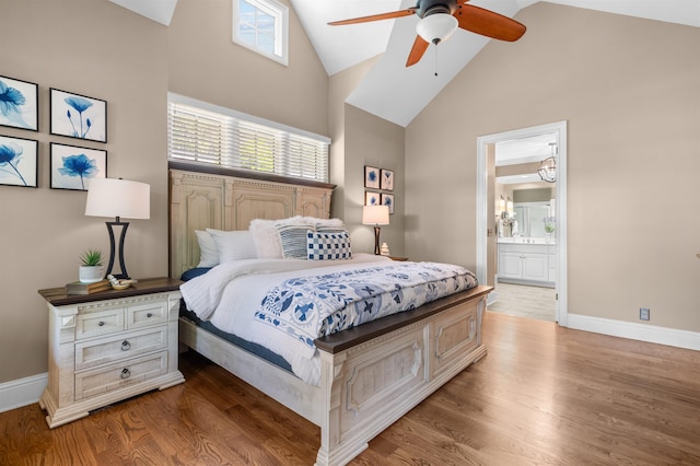 bedroom with ceiling fan, wood-type flooring, connected bathroom, and high vaulted ceiling