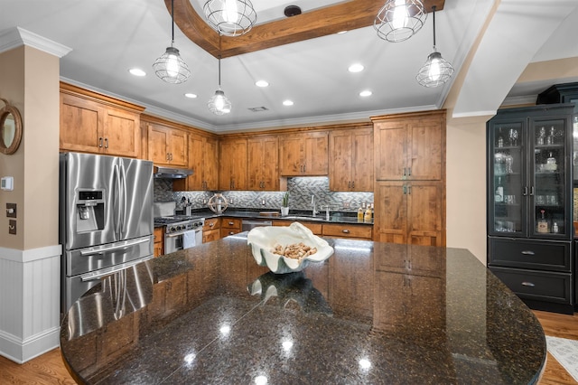 kitchen with pendant lighting, a spacious island, stainless steel appliances, and dark stone countertops