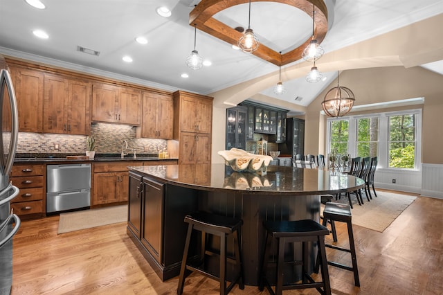 kitchen featuring sink, decorative light fixtures, light hardwood / wood-style floors, and a kitchen island