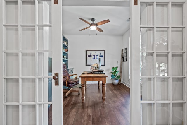 office featuring dark hardwood / wood-style floors, a barn door, ceiling fan, and french doors