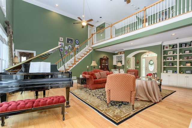 1811 Snug Harbor Dr, Greensboro, GA 30642 - living area with arched walkways, a ceiling fan, a high ceiling, crown molding, and wood finished floors