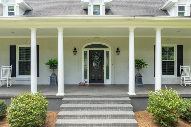 1811 Snug Harbor Dr, Greensboro, GA 30642 - view of exterior entry featuring covered porch, stucco siding, and a shingled roof