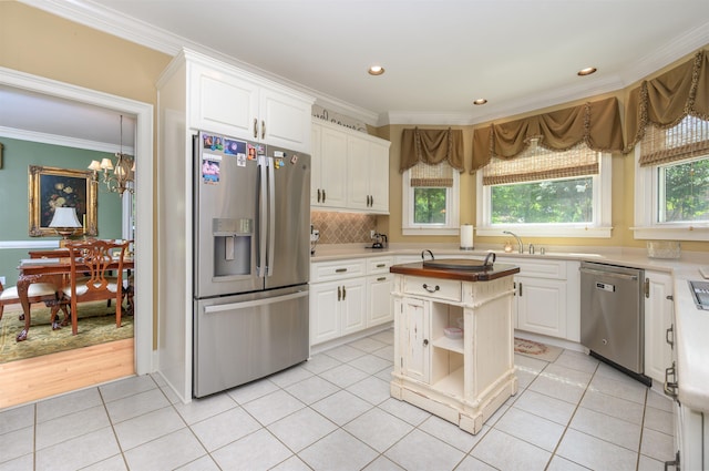 1811 Snug Harbor Dr, Greensboro, GA 30642 - kitchen with appliances with stainless steel finishes, crown molding, light countertops, white cabinets, and recessed lighting
