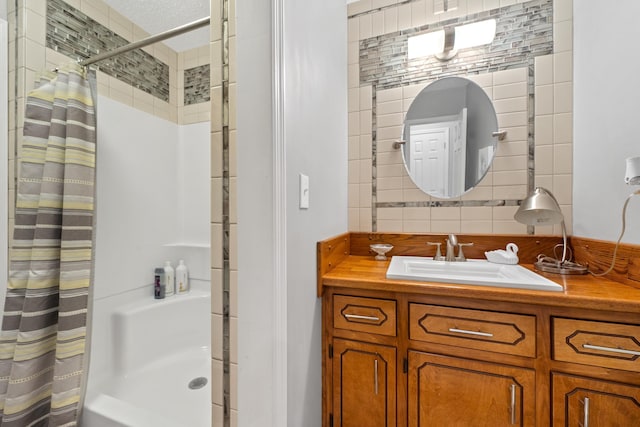 bathroom with a shower with curtain, vanity, and backsplash