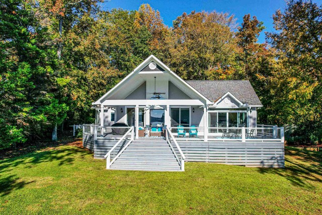 back of house with a wooden deck, a lawn, and ceiling fan