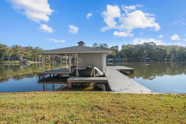 view of dock with a water view and a lawn