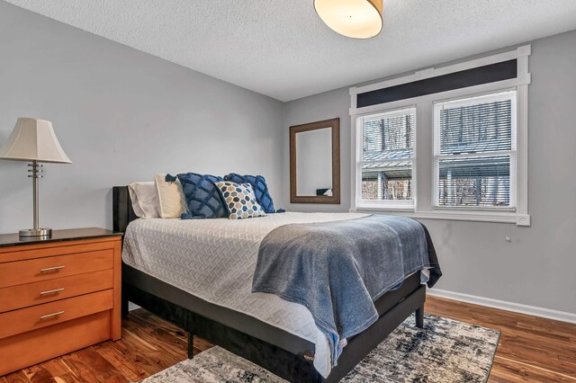 bedroom featuring dark wood-type flooring and a textured ceiling