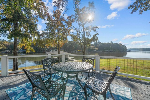 wooden terrace with a lawn and a water view