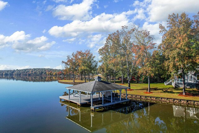 dock area with a water view and a lawn