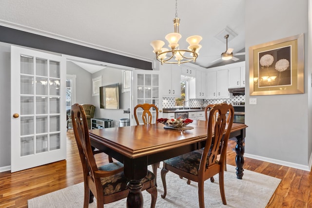 dining room featuring lofted ceiling, a chandelier, and light hardwood / wood-style floors