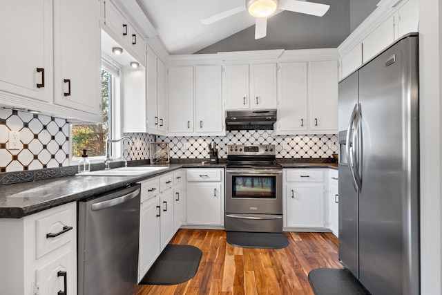 kitchen featuring lofted ceiling, sink, white cabinetry, appliances with stainless steel finishes, and hardwood / wood-style flooring