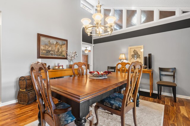 dining area with hardwood / wood-style floors and a chandelier