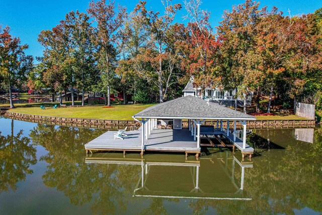 view of dock with a water view and a yard