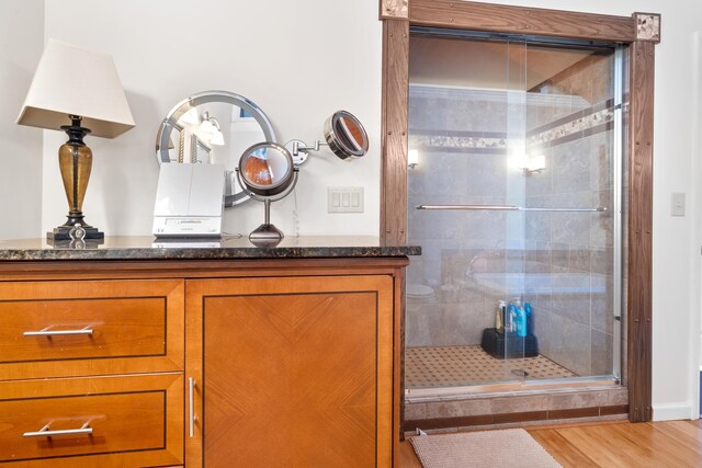 bathroom featuring wood-type flooring and a shower with shower door