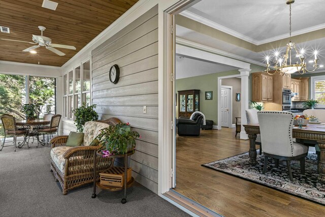 dining room with crown molding, wood ceiling, hardwood / wood-style flooring, ceiling fan with notable chandelier, and a raised ceiling