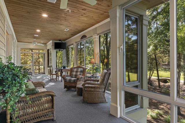 unfurnished sunroom featuring ceiling fan, a healthy amount of sunlight, and wooden ceiling