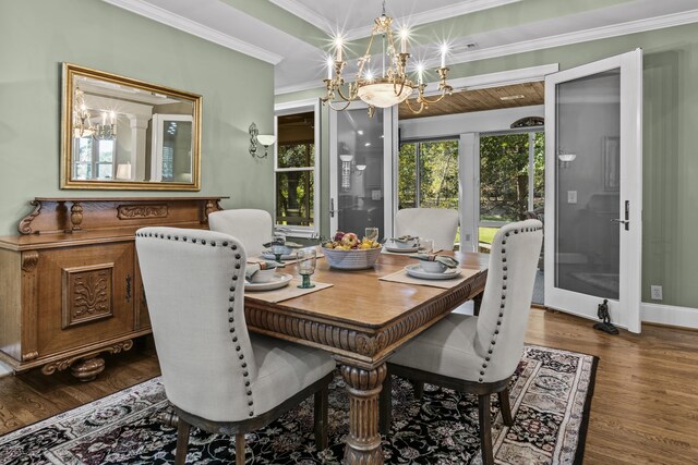 dining area with crown molding, hardwood / wood-style floors, and a notable chandelier