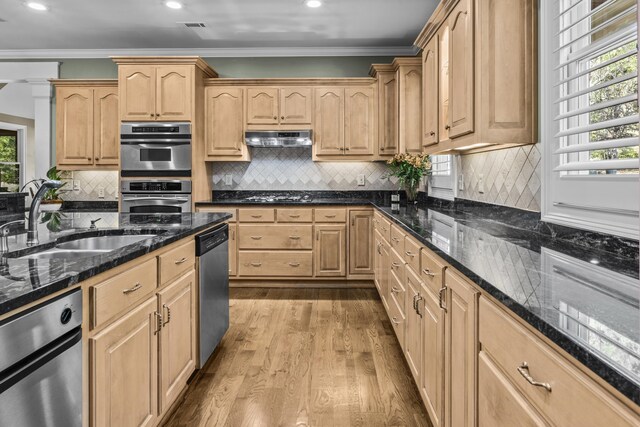 kitchen featuring sink, crown molding, appliances with stainless steel finishes, dark stone countertops, and light brown cabinets