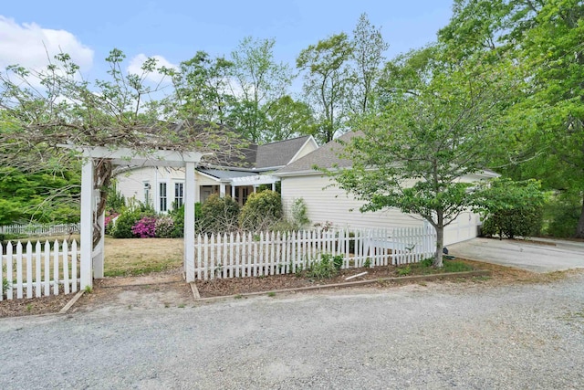 view of front facade featuring a shingled roof and a fenced front yard