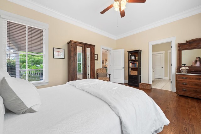 bedroom with crown molding, ceiling fan, wood finished floors, and baseboards