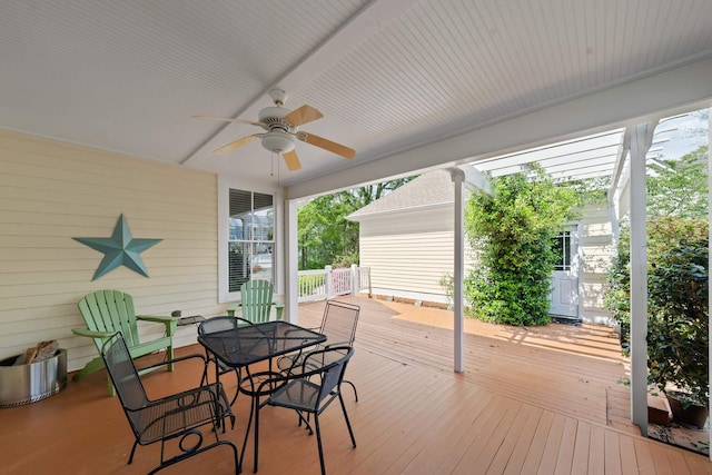 wooden deck featuring outdoor dining space and a ceiling fan