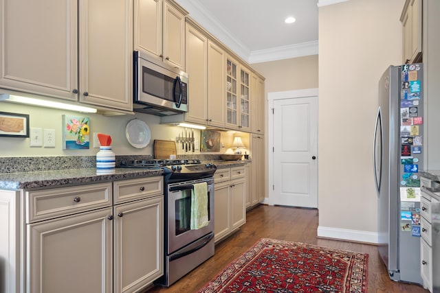 kitchen featuring glass insert cabinets, crown molding, light stone countertops, dark wood-type flooring, and appliances with stainless steel finishes