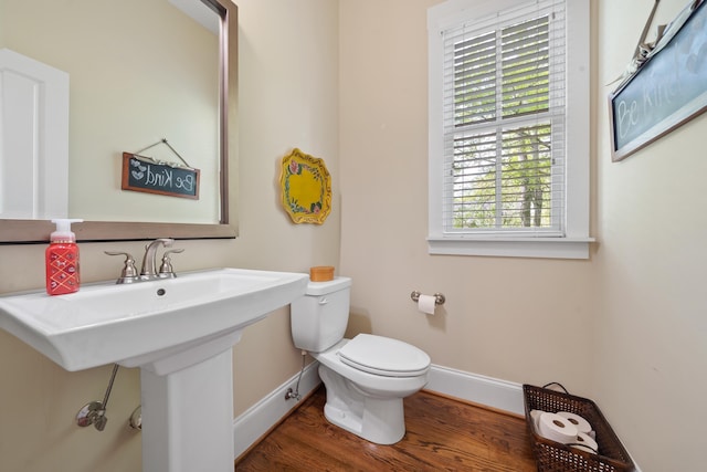 bathroom with baseboards, toilet, and wood finished floors