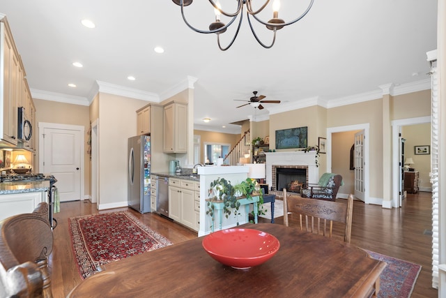 dining area featuring baseboards, dark wood-type flooring, ceiling fan with notable chandelier, and crown molding