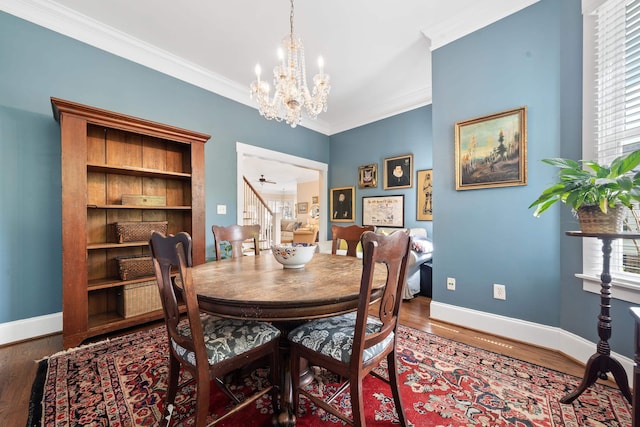 dining area with a chandelier, wood finished floors, baseboards, and ornamental molding