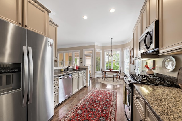 kitchen with dark wood-type flooring, ornamental molding, recessed lighting, appliances with stainless steel finishes, and a sink