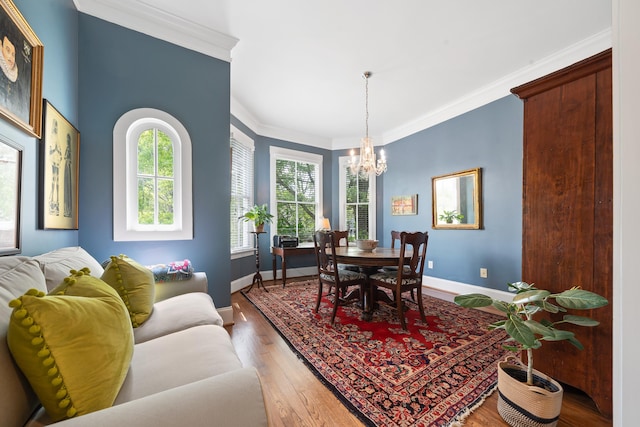 dining room featuring an inviting chandelier, light wood-style floors, baseboards, and crown molding