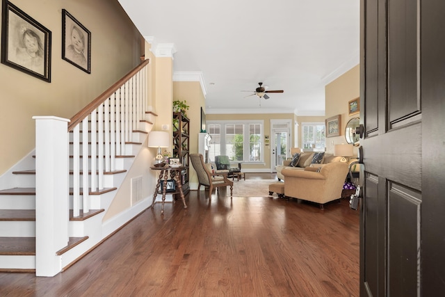 living room featuring ornamental molding, a ceiling fan, visible vents, dark wood-style flooring, and stairs