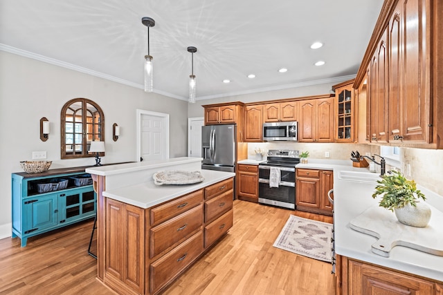 kitchen featuring a breakfast bar, sink, a kitchen island, pendant lighting, and stainless steel appliances