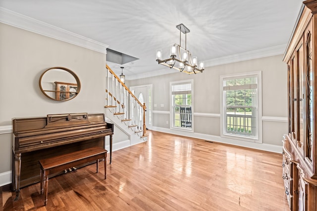 interior space featuring crown molding, a notable chandelier, and light hardwood / wood-style flooring