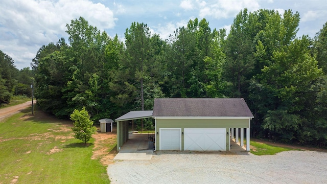 garage featuring a carport and a lawn