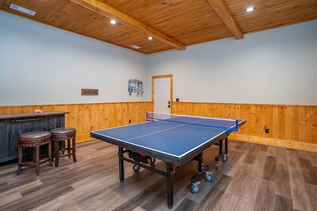 game room with beam ceiling, wood ceiling, dark hardwood / wood-style floors, and indoor bar