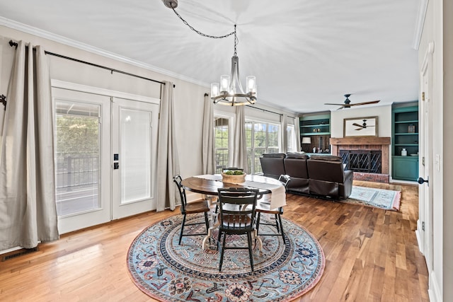 dining space with a fireplace, crown molding, and wood-type flooring