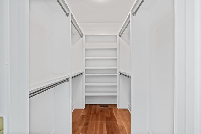 walk in closet with hardwood / wood-style floors