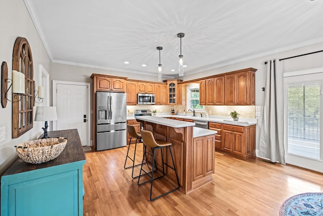 kitchen featuring a breakfast bar area, light hardwood / wood-style flooring, backsplash, stainless steel appliances, and a center island