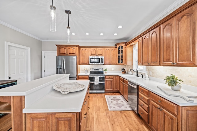 kitchen with sink, light hardwood / wood-style flooring, hanging light fixtures, stainless steel appliances, and a center island