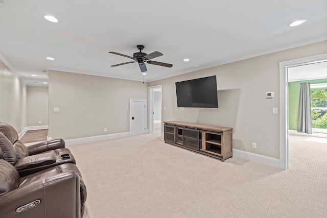 carpeted living room with crown molding and ceiling fan